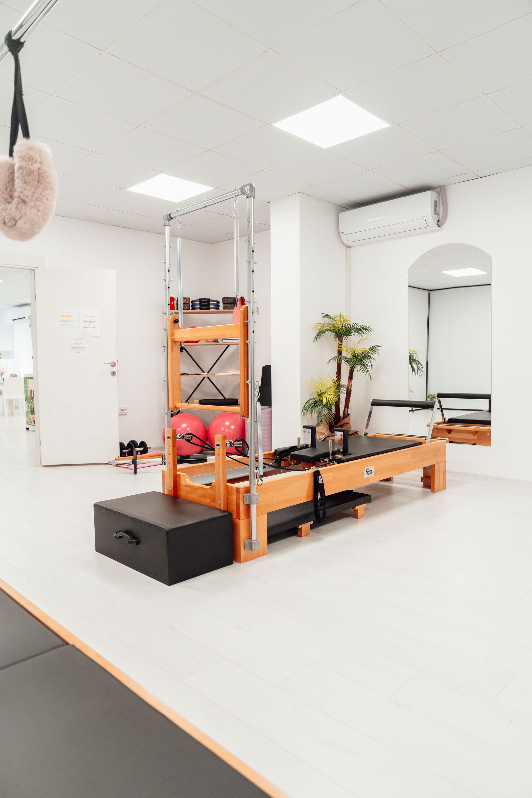 A bright Pilates studio with wooden reformers, mats and exercise balls
